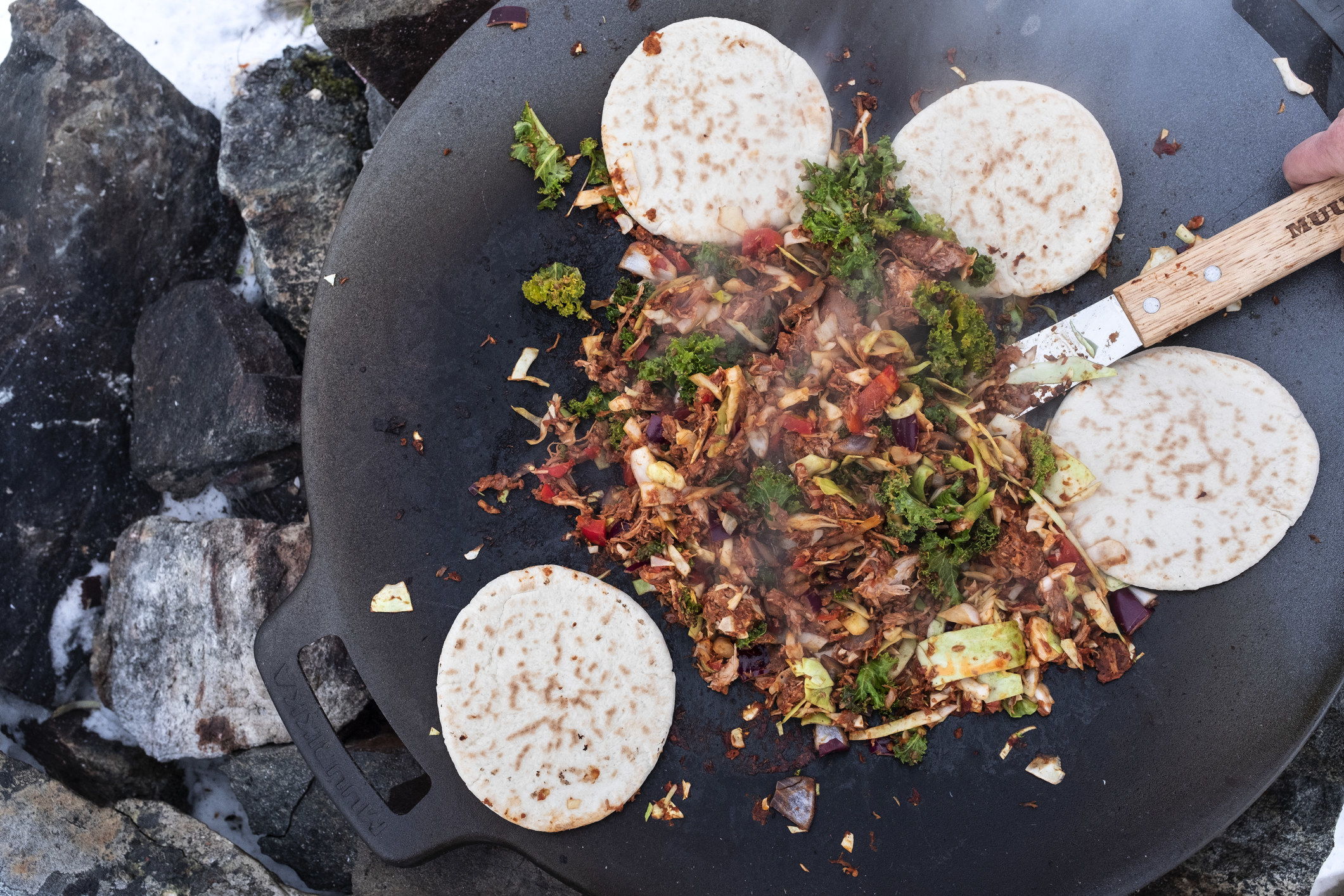 Cooking tortillas and stir fry on a grill.