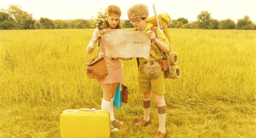 The kids from &quot;Moonrise Kingdom&quot; reading a map in a field.