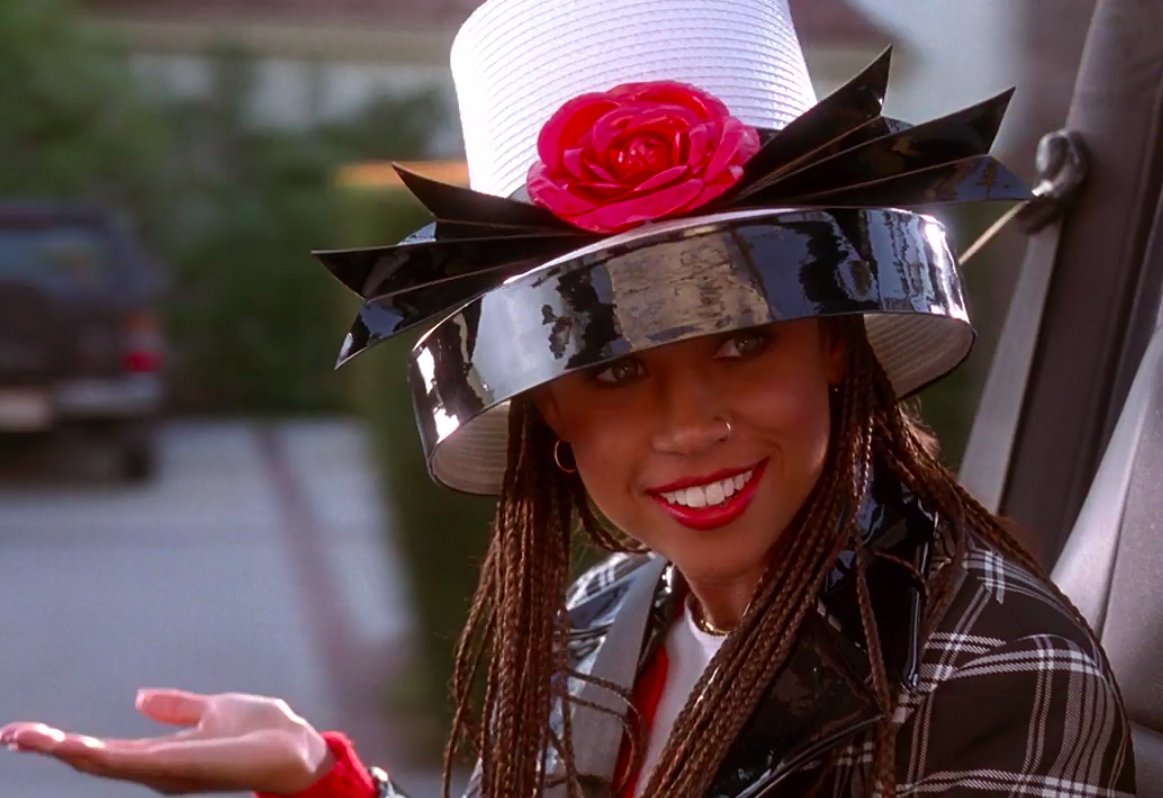 Dionne wearing a matching plaid outfit and a very large hat