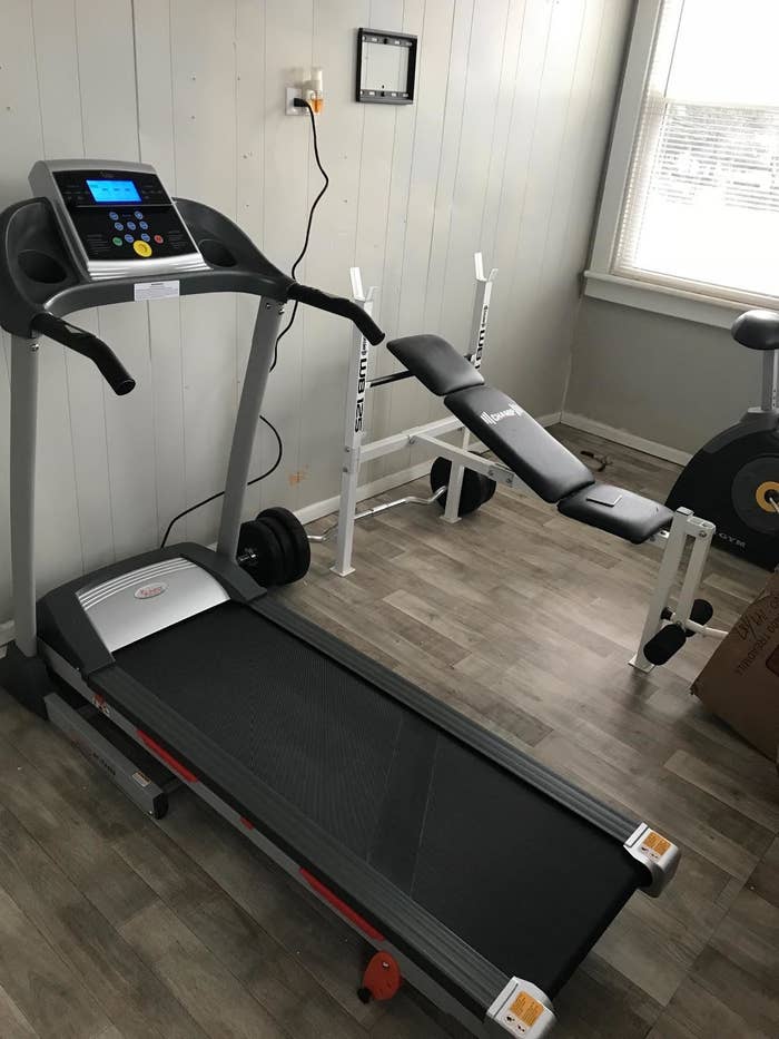 reviewer photo of the black treadmill in a home gym setup