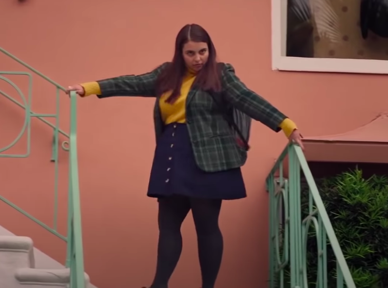 Amy wearing tights, a mini skirt, a turtleneck, and a blazer
