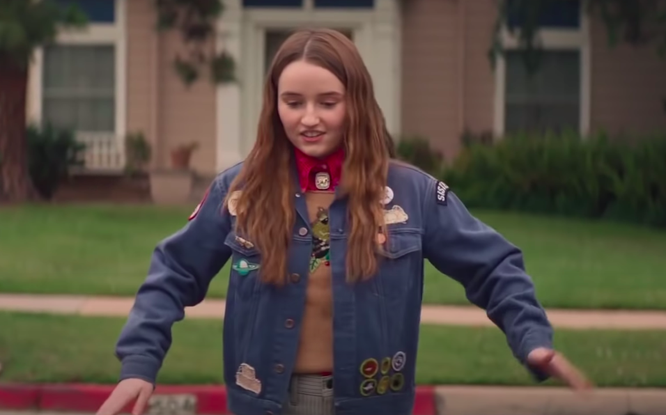 Amy wearing sneakers, pants, a jean jacket with patches, a sweater, and a shirt