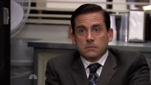 GIF of Michael Scott putting his hands under his chin to listen