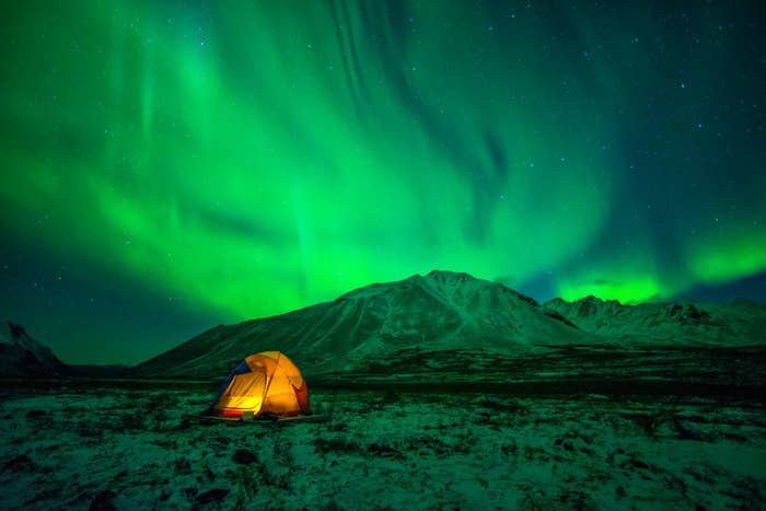 Tent camping under Northern Lights (Aurora Borealis) at Tombstone Territorial Park in Yukon.