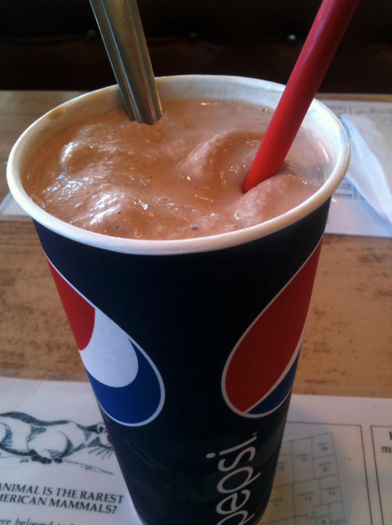 A pepsi drink container filled with chocolate thickshake
