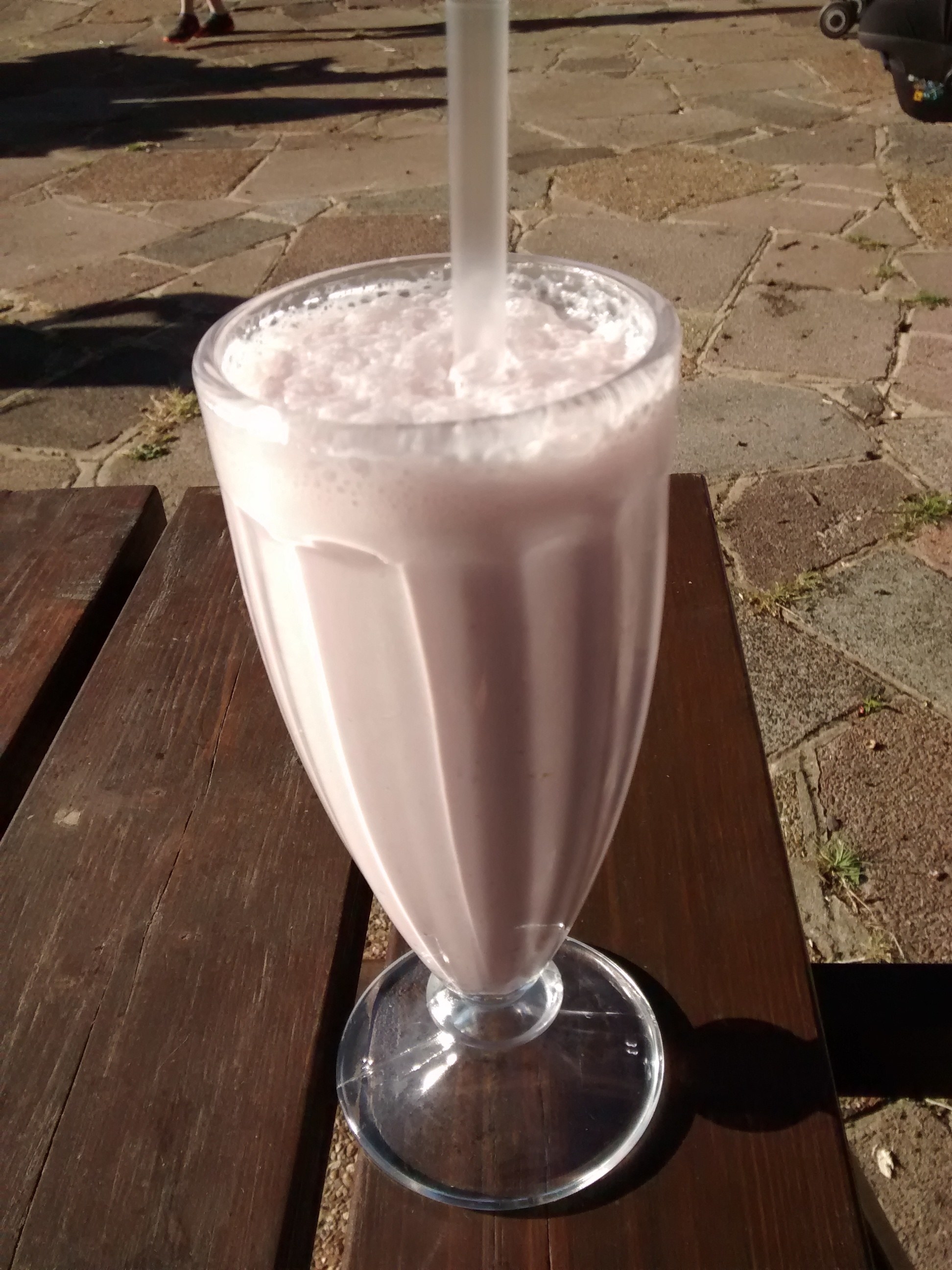 A tall glass filled with chocolate milkshake