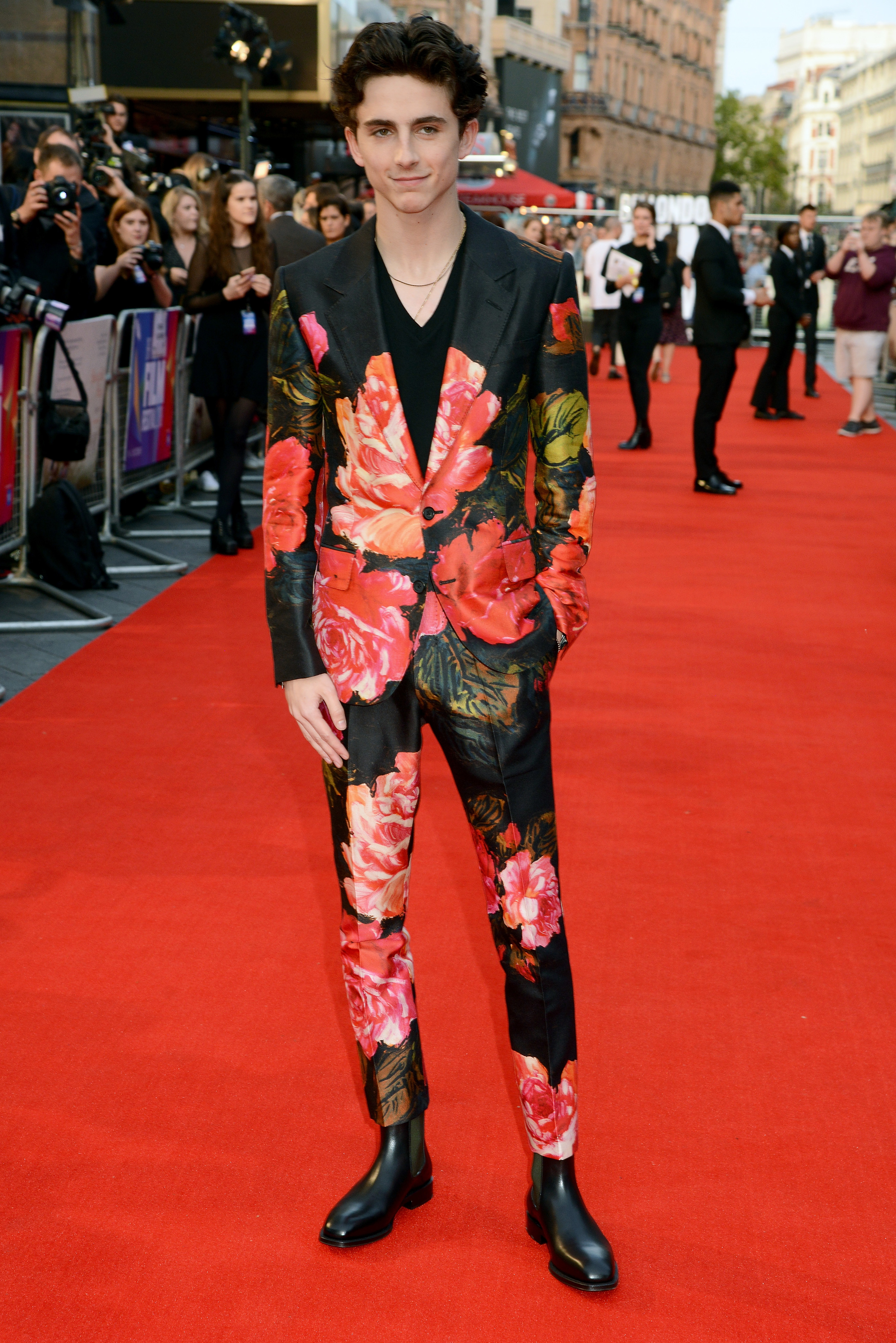 Timothée wears a black suit white large red floral detailing