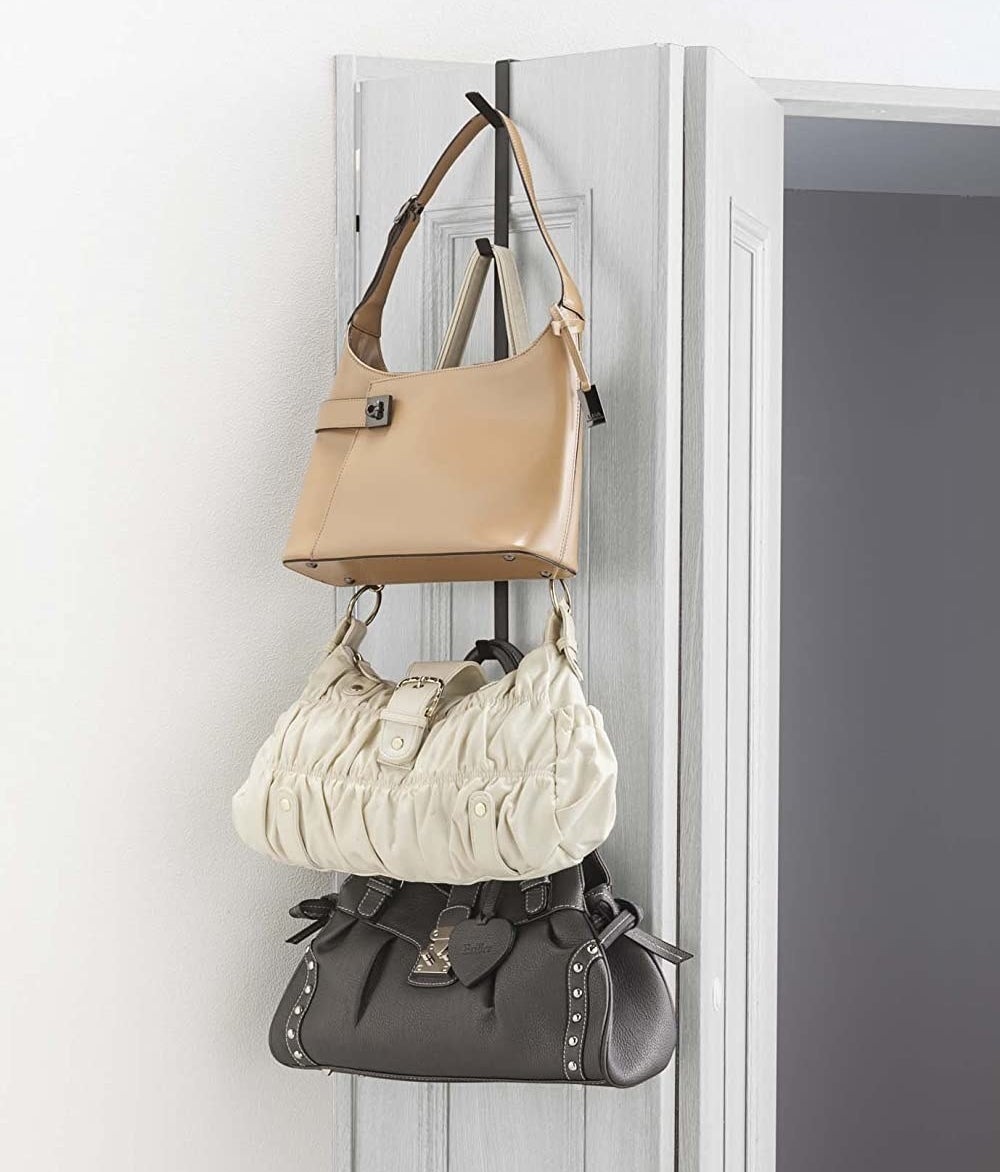 Three bags stacked on top of each other, hanging off of the over-door hanger