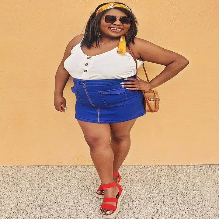 a reviewer photo of someone wearing the tank tucked into a denim skirt 