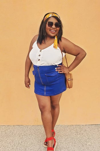 a reviewer photo of someone wearing the tank tucked into a denim skirt 