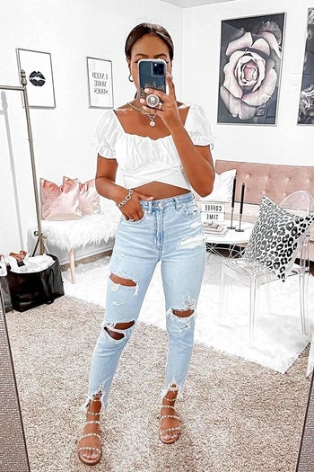 a reviewer wearing a pair of jeans and the white cropped top 