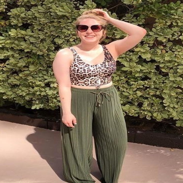 a reviewer wearing the pants in khaki green with a cropped leopard tank top 