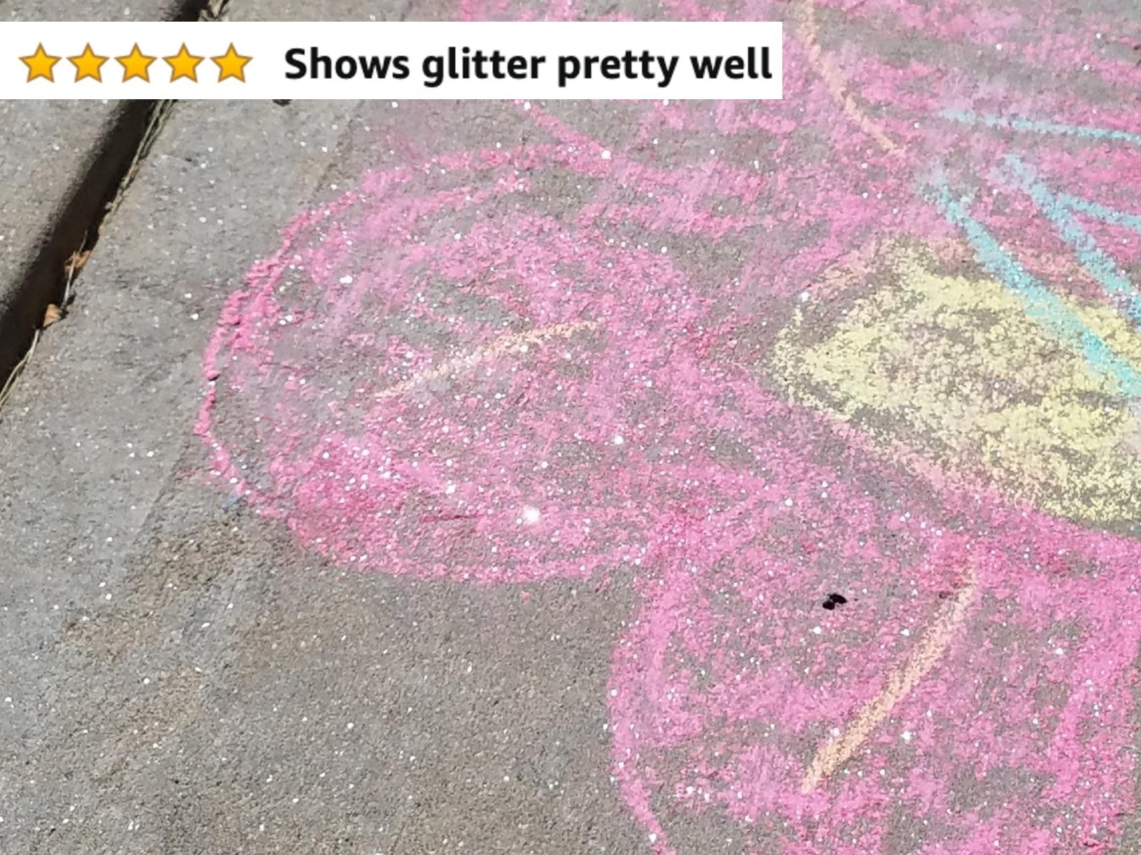 Reviewer&#x27;s photo showing a pink and yellow flower they drew on the sidewalk using glitter chalk