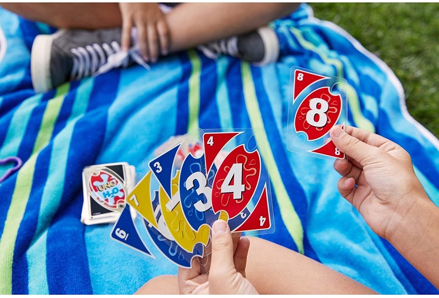 A pack of waterproof cards near a beach towel