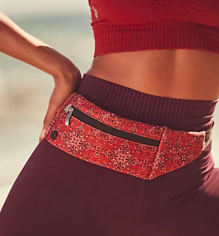 A close up of a person wearing a paisley-patterned belt bag