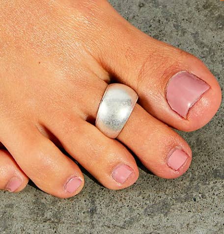 A brushed silver toe ring on a person&#x27;s toe
