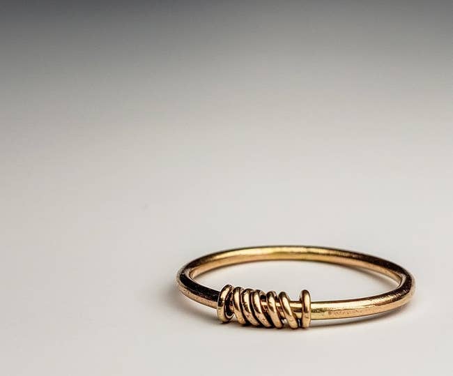 simple gold band with seven small round rings around it