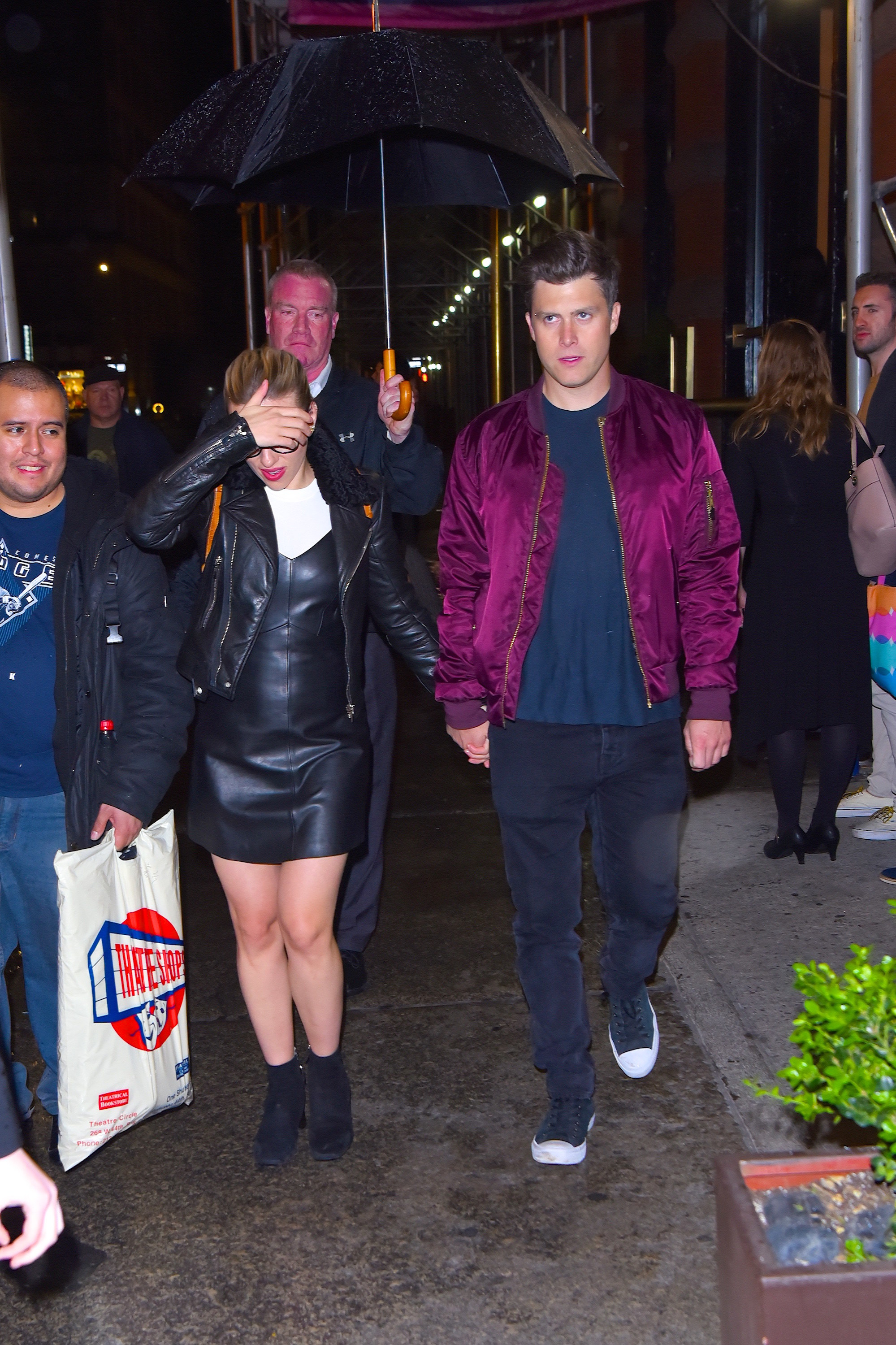 johansson shielding her face while walking hand in hand with jost