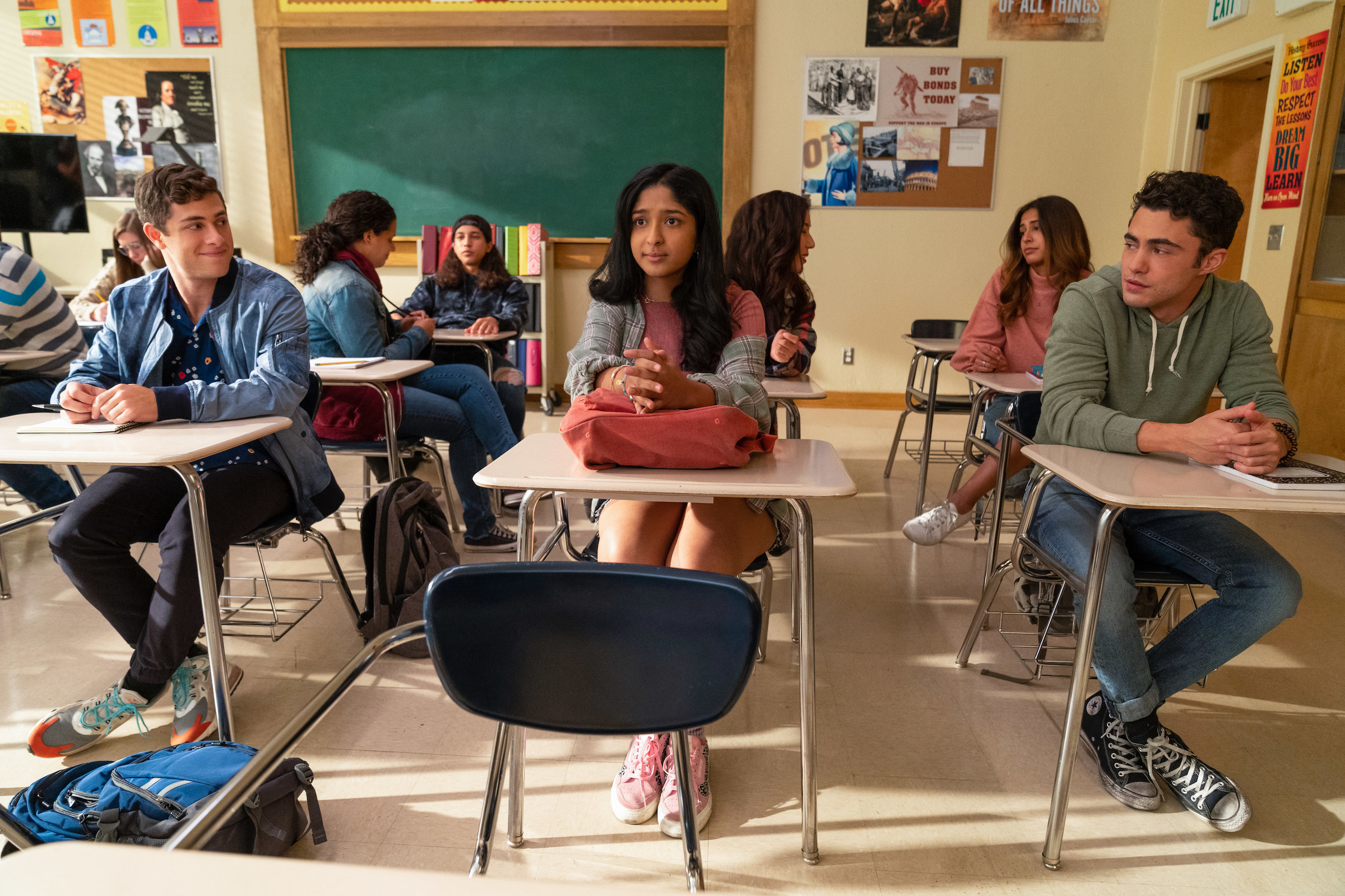 Devi sitting at her desk in class while her classmates sit around her