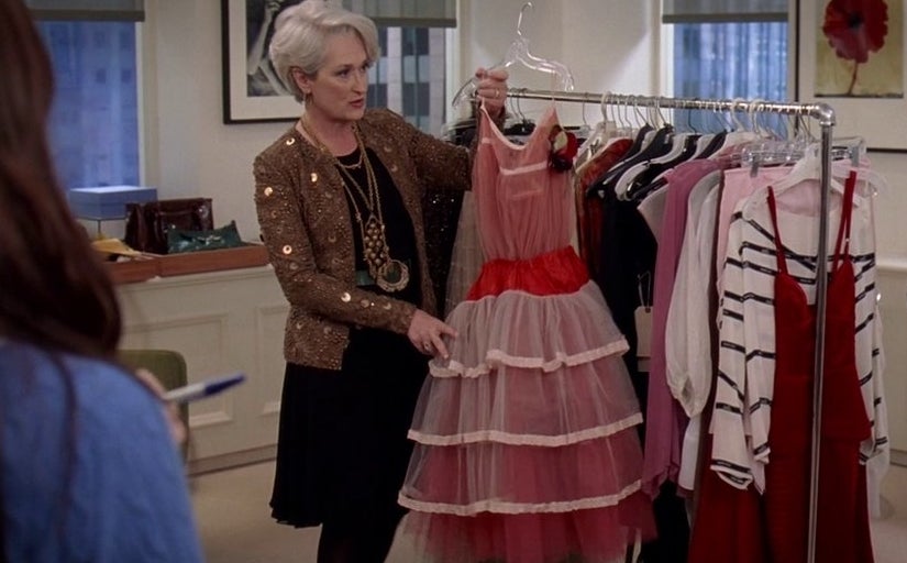 Miranda holding up a dress for a photo shoot