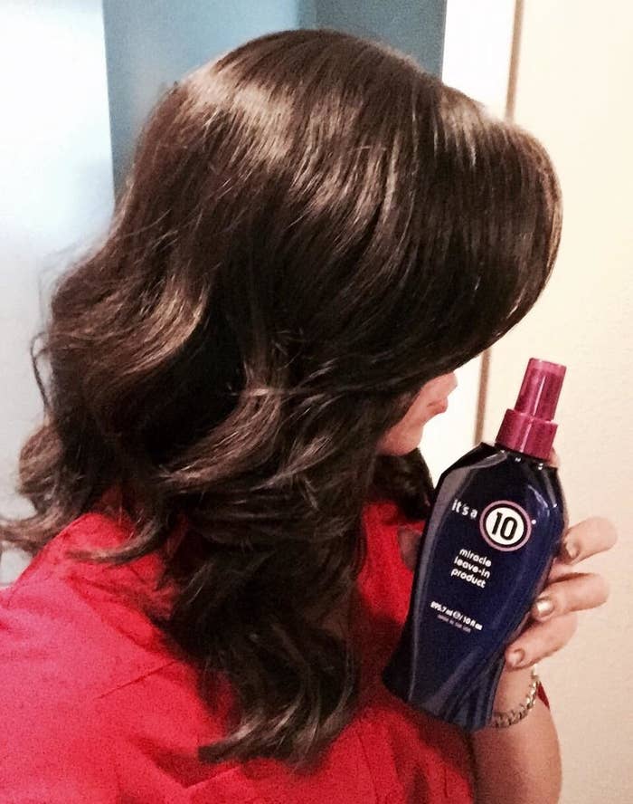 Reviewer holding product while showing off hair