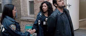 Amy Santiago and Rosa Diaz do a complicated handshake while arresting a man