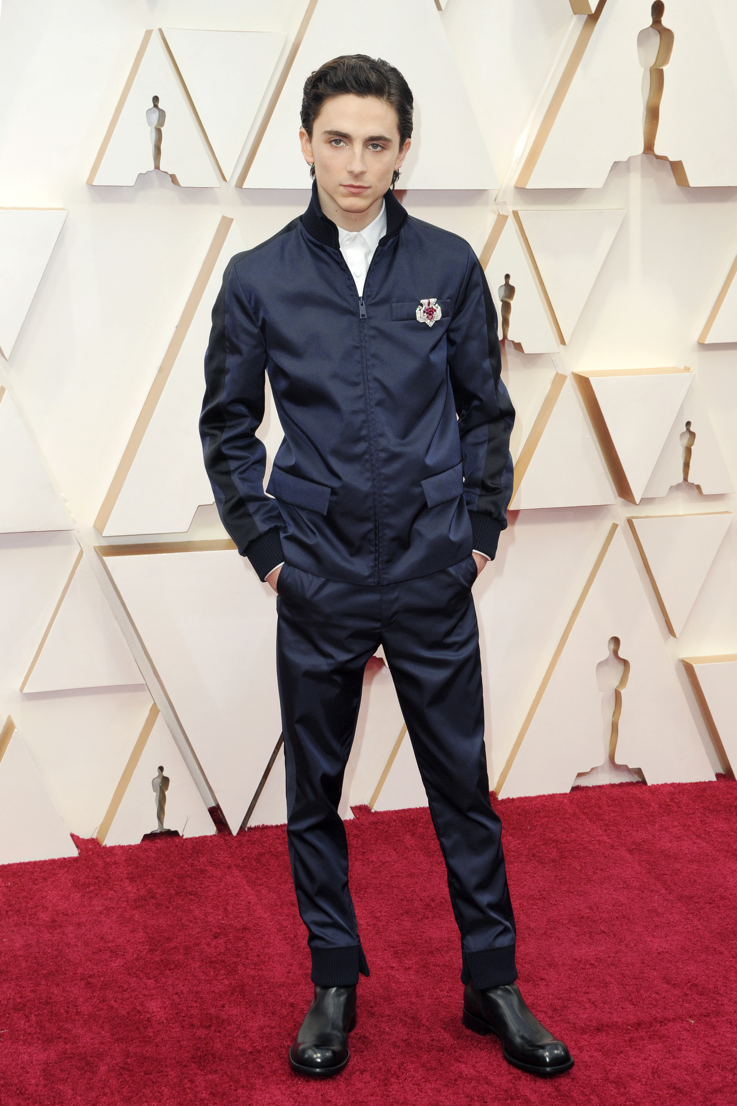 Timothée wears a navy nylon zip-up jacket and matching pants