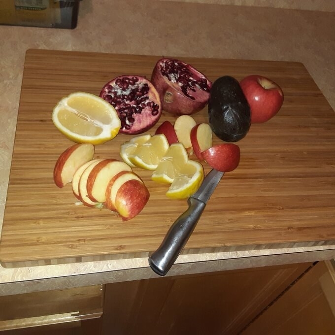 a bamboo cutting board being used to chop fruit