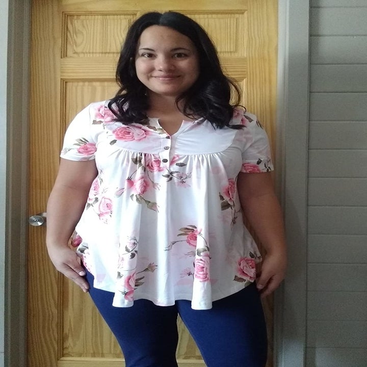 a reviewer wearing the short sleeve tunic in white with a pink floral print 