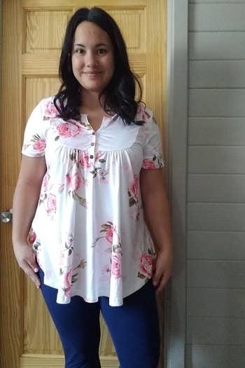 a reviewer wearing the short sleeve tunic in white with a pink floral print 