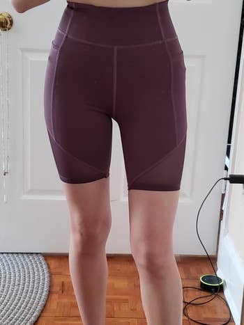 Reviewer wearing maroon bike shorts with mesh panels
