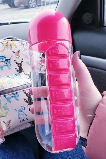 reviewer holding the pink water bottle