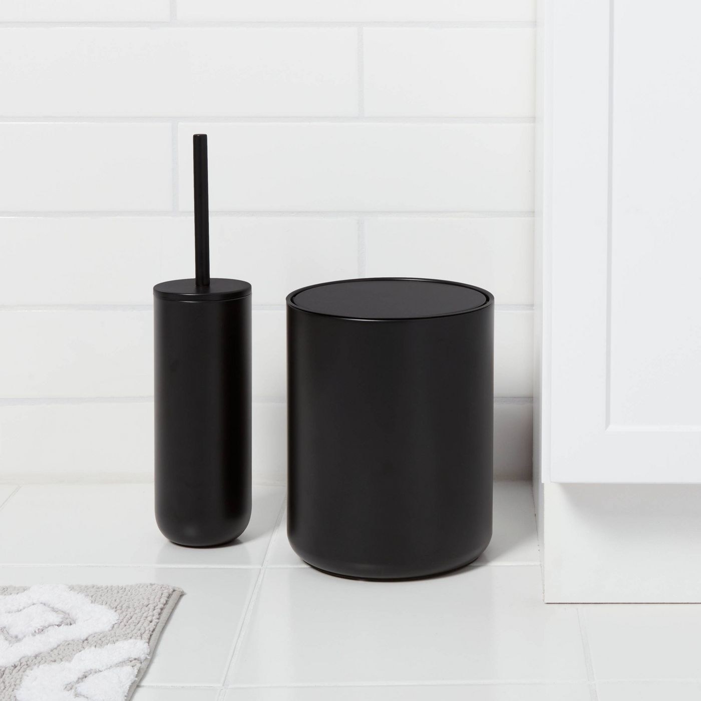 a matte black toilet brush and matching trash can