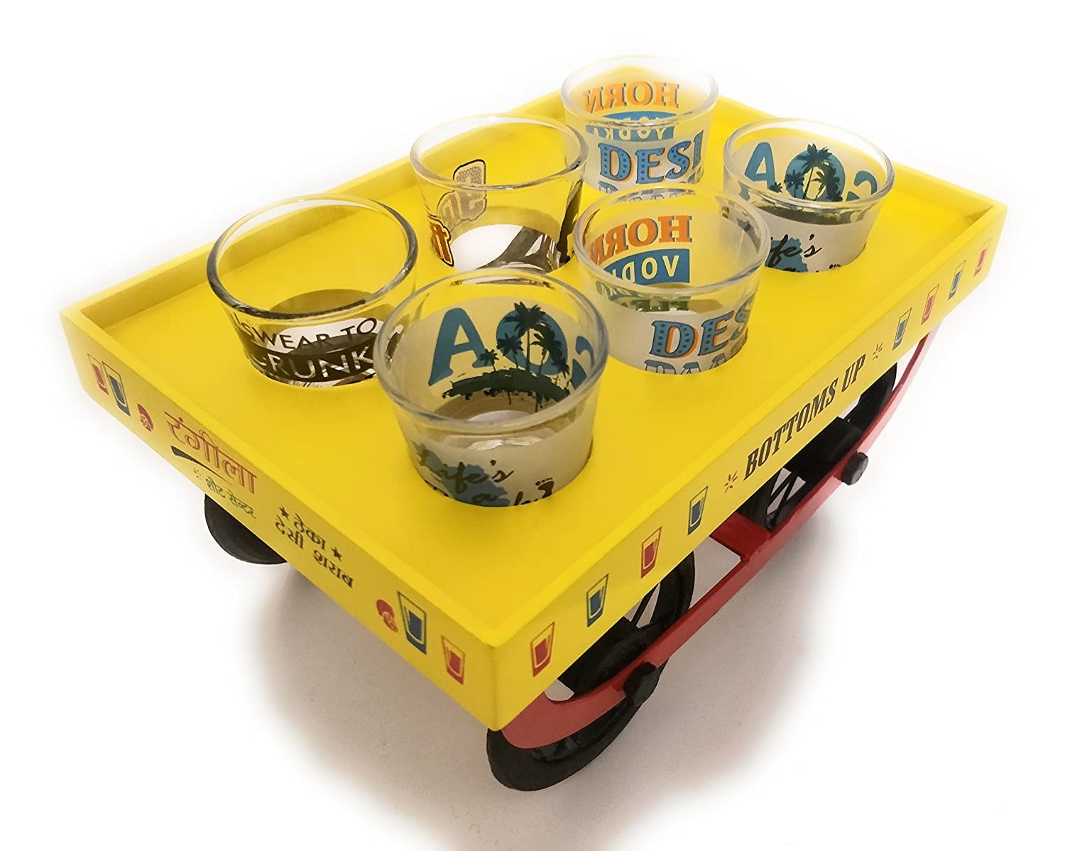 A bright yellow wooden cart with black wheels containing 6 different shot glasses each with a different funny message on it