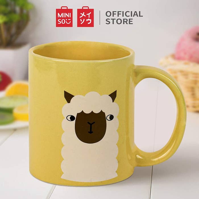 A yellow mug with an alpaca on it