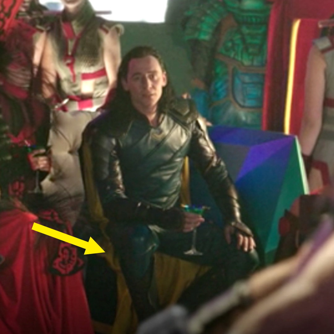 Loki sitting in the Grandmaster&#x27;s palace, his cape showing bright yellow on the underside