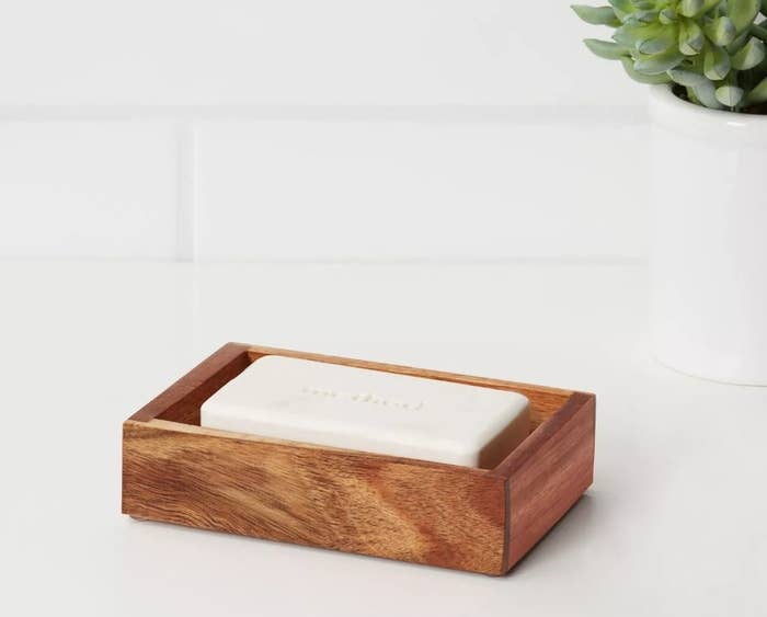 Dark wooden soap holder with white bar of soap
