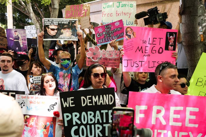 A group of fans hold up signs asking to free Britney