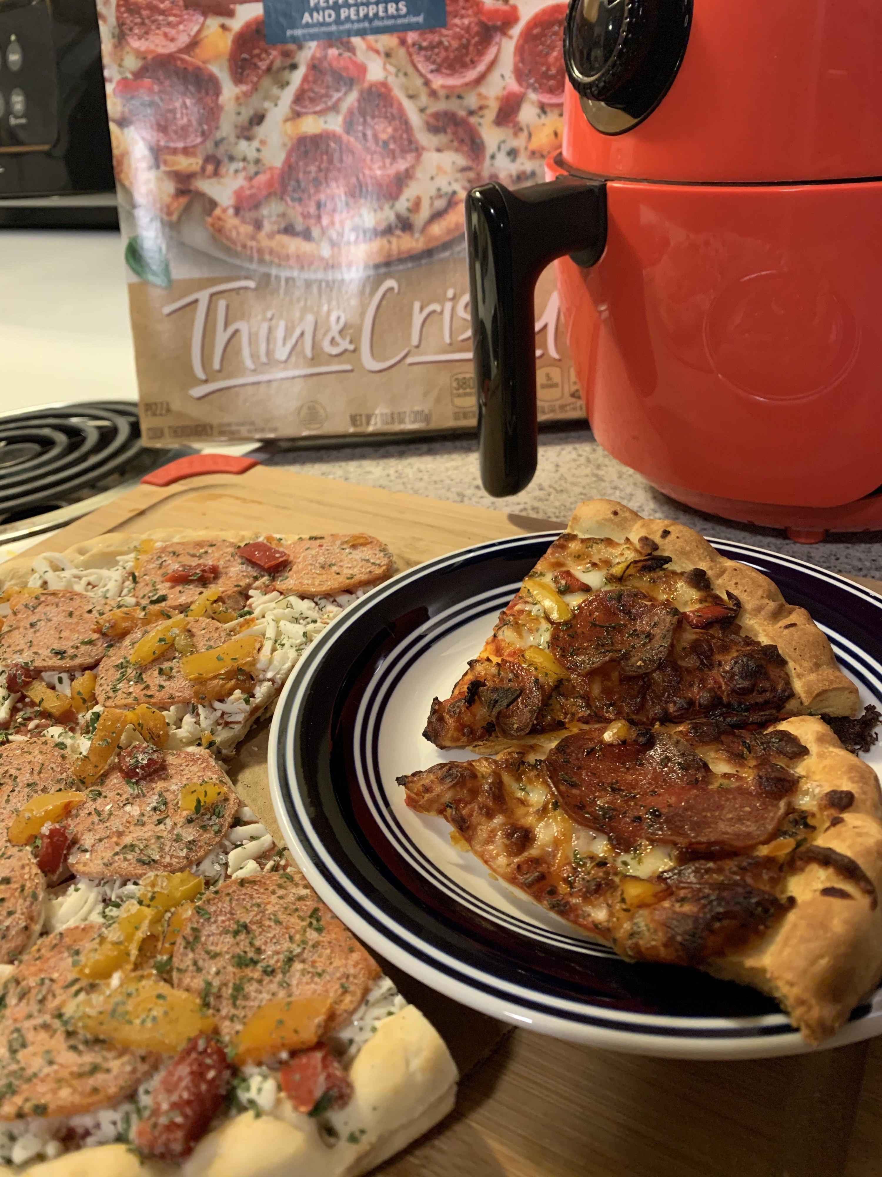 Frozen pizza and two slices that were heated up in the air fryer.