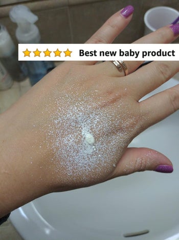 Reviewer's photo showing the diaper rash cream sprayed on their hand