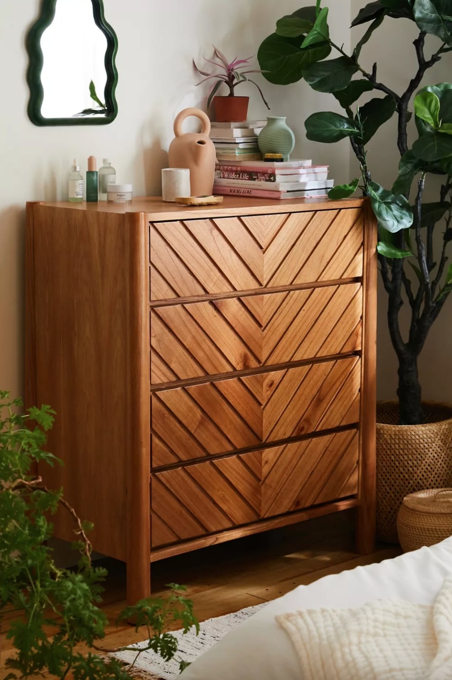 the four drawer light wood dresser with chevron patterns carved into the wood