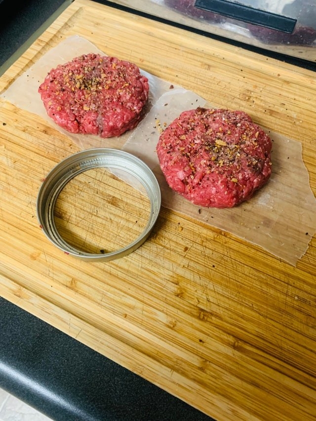 Two perfectly shaped hamburger patties.