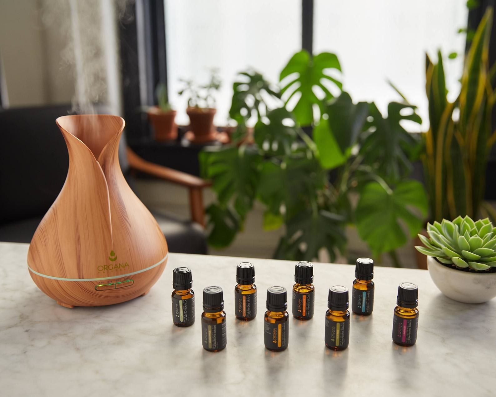 the faux wood diffuser and eight essential oil bottles on a marble surface