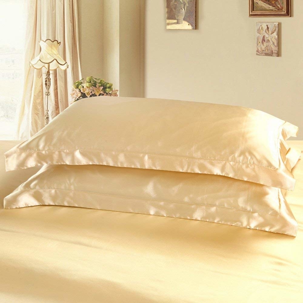 Golden satin pillowcases on two pillows