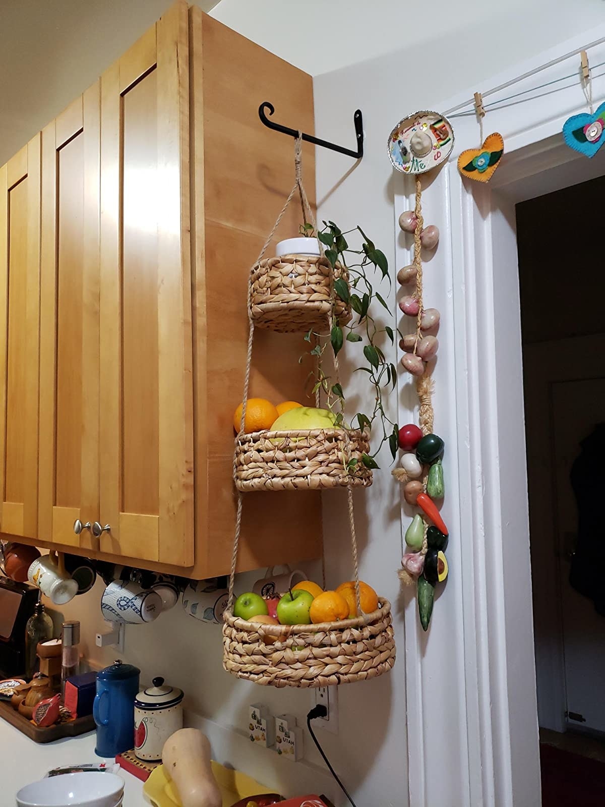 reviewer image of the the woven three tier fruit basket hanging in a kitchen