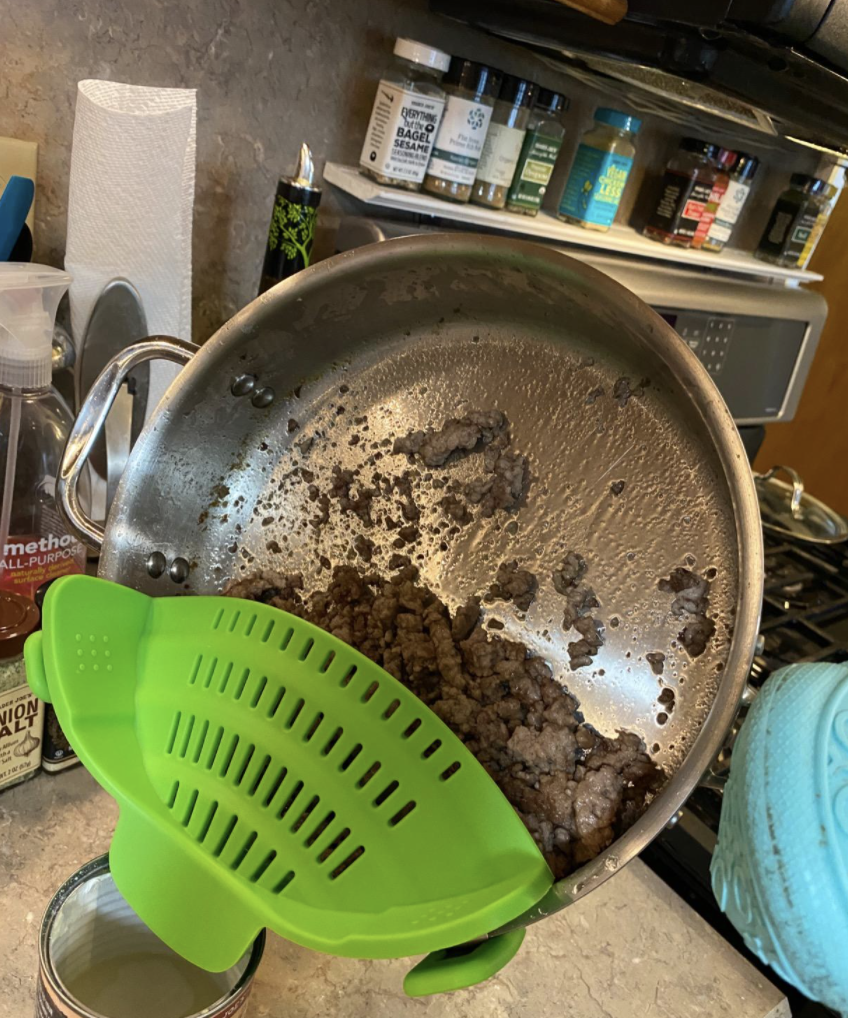 A reviewer dumping grease with the strainer
