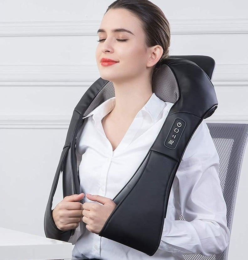 a person wearing the massager over their shoulders, with their hands through the slots at the front so they can rest their arms