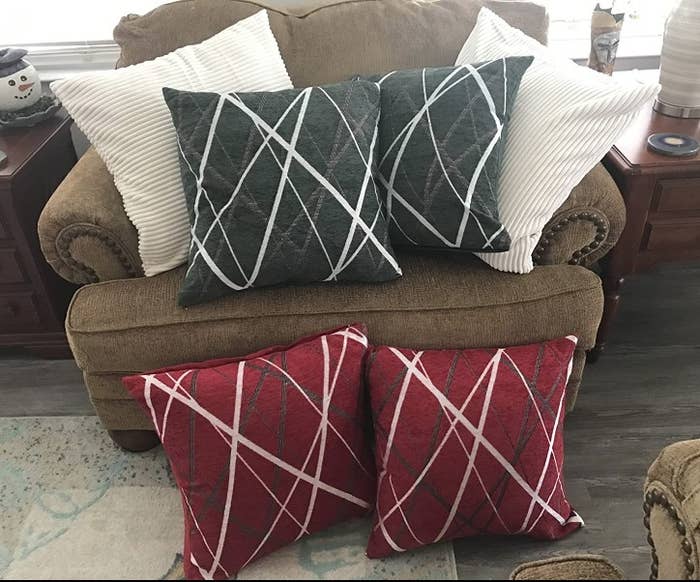 A set of red throw pillows with a modern white/grey design and a set of grey throw pillows with a white/grey modern design