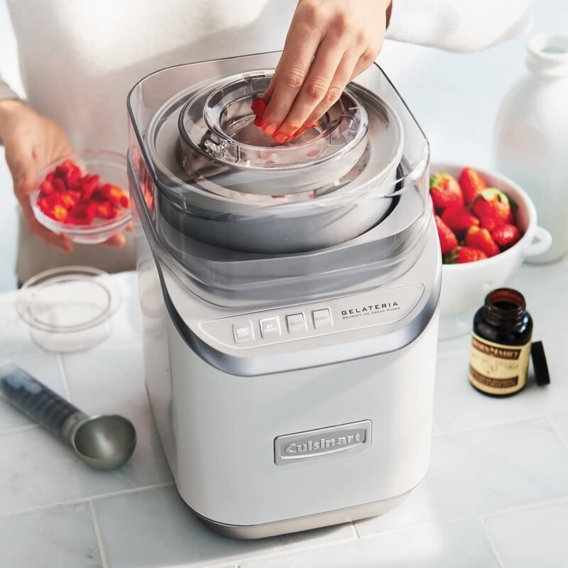 a model putting strawberries into the ice cream maker