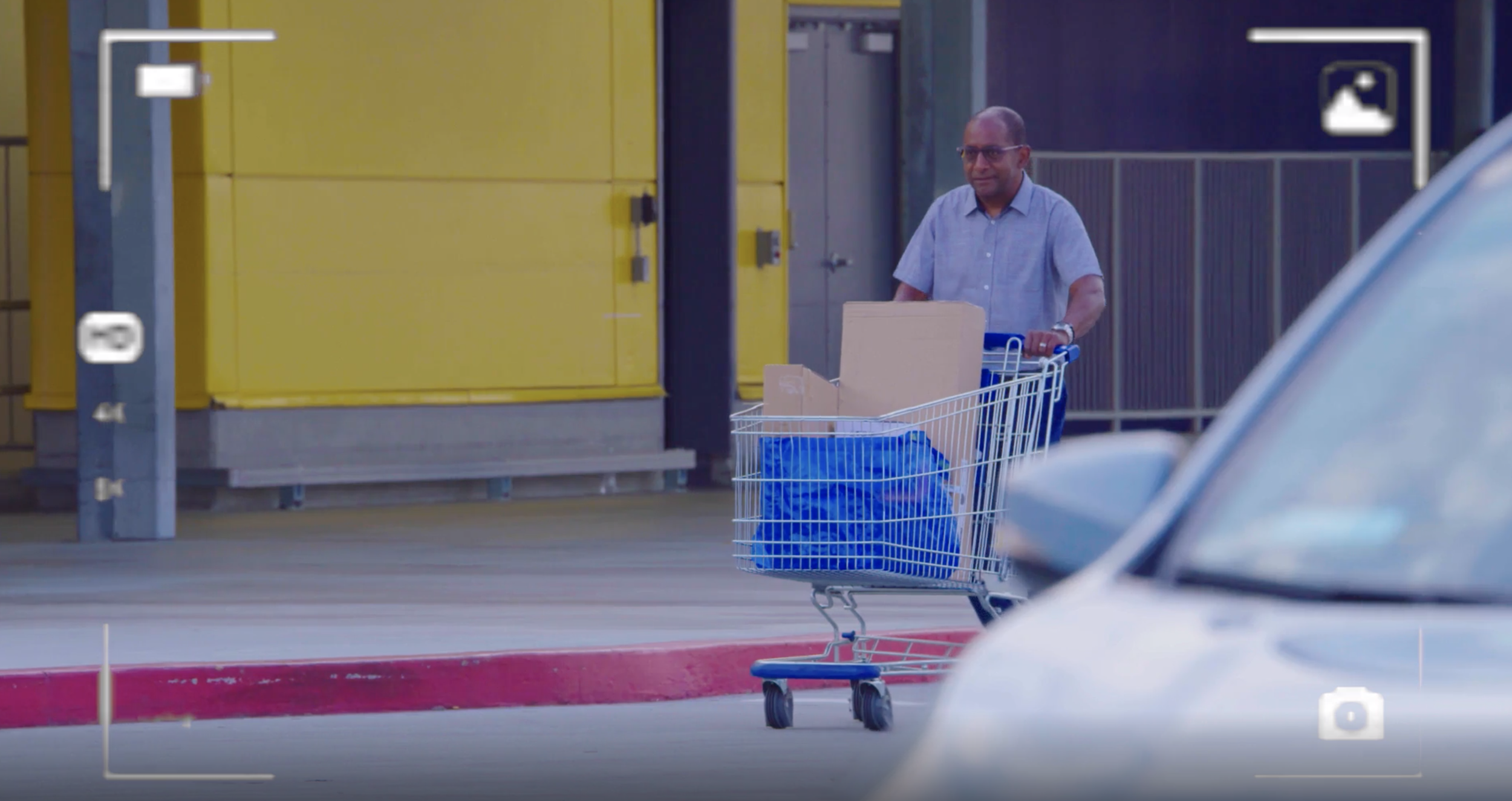 Picture of man pushing shopping cart outside of IKEA store.